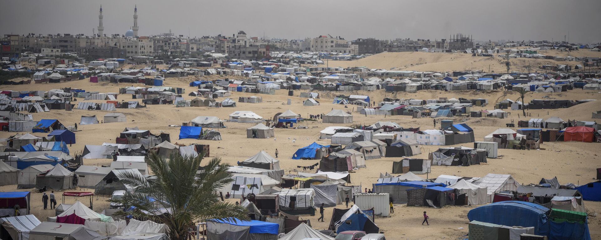 Palestinians displaced by the Israeli air and ground offensive on the Gaza Strip walk through a makeshift tent camp in Rafah, Gaza, Friday, May 10, 2024. (AP Photo/Abdel Kareem Hana) - Sputnik भारत, 1920, 01.06.2024