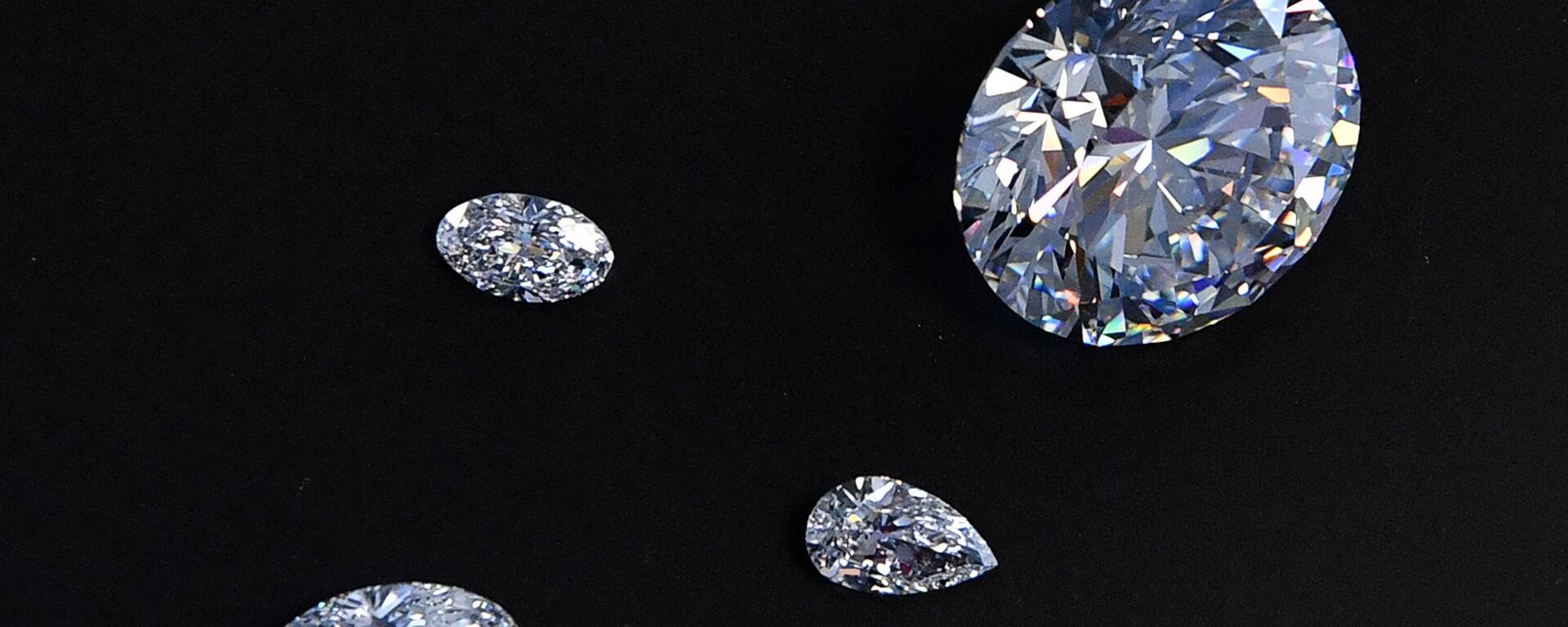 A view of the main 51.38-carat round-cut diamond, the Dynasty, among other gems from Russian diamond miner Alrosa’s Dynasty polished diamonds collection in Moscow on August 3, 2017. The collection of five polished stones was manufactured from a 179-carat Romanovs rough diamond, extracted at the company’s Nyurbinskaya kimberlite pipe in Russia's far northeast region of Yakutia in 2015. Alrosa plans to sell the whole collection in one set at a special online auction in November with the starting price not less than $10 million, according to the company’s CEO Ivanov. (Photo by Yuri KADOBNOV / AFP) - Sputnik भारत, 1920, 27.08.2024