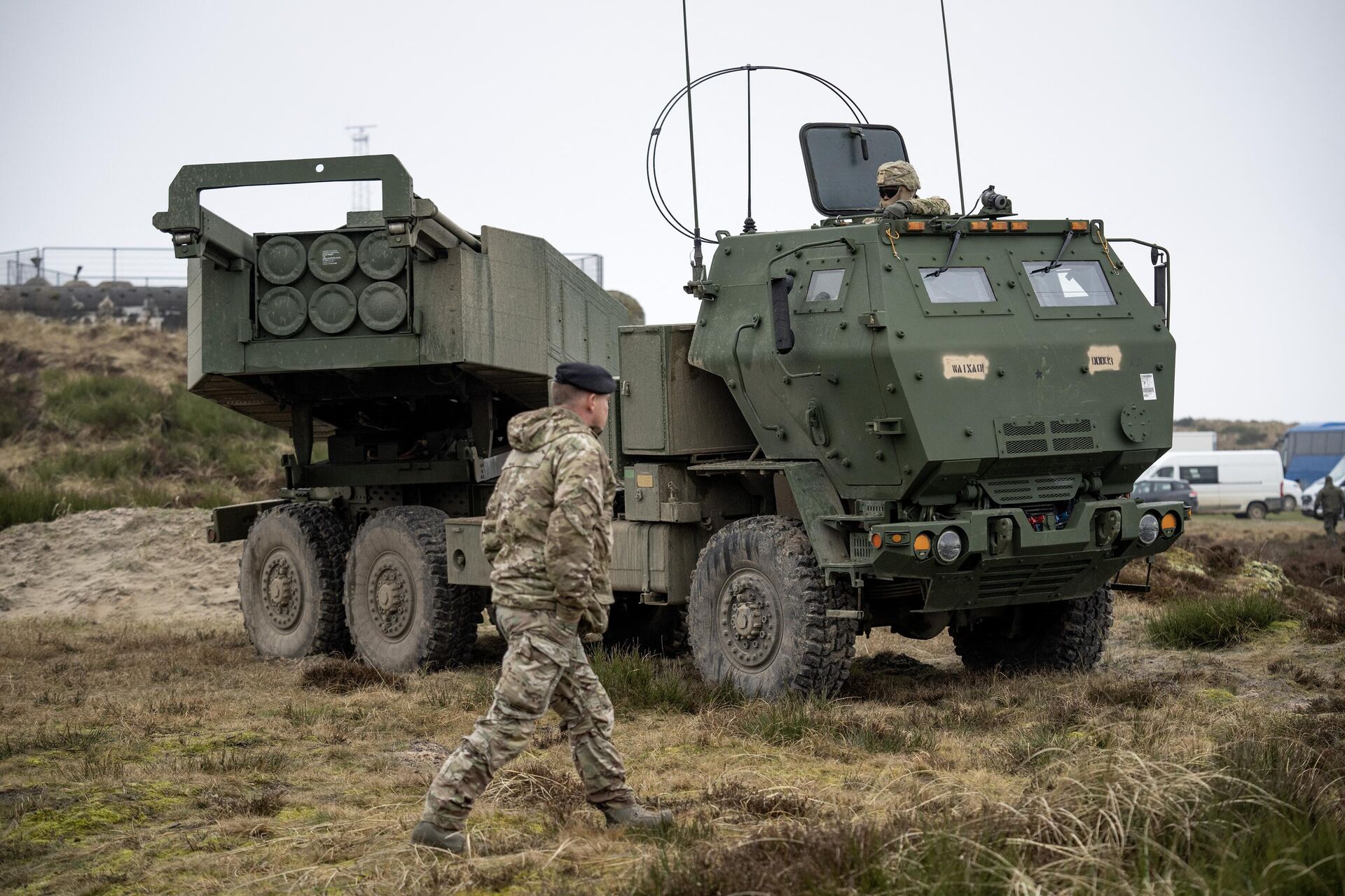 A soldier walks in front of a M142 HIMARS High Mobility Artillery Rocket System during the Dynamic Front military exercise led by the United States at the Oksboel Training and Shooting Range in Oksbol, Denmark on March 30, 2023. - Sputnik India, 1920, 15.06.2024