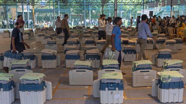 Election officials collect Electronic Voting Machines (EVMs) and other election material for their respective polling booths on the eve of the fifth phase of the six-week-long national election in Mumbai, India, Sunday, May 19, 2024. - Sputnik India