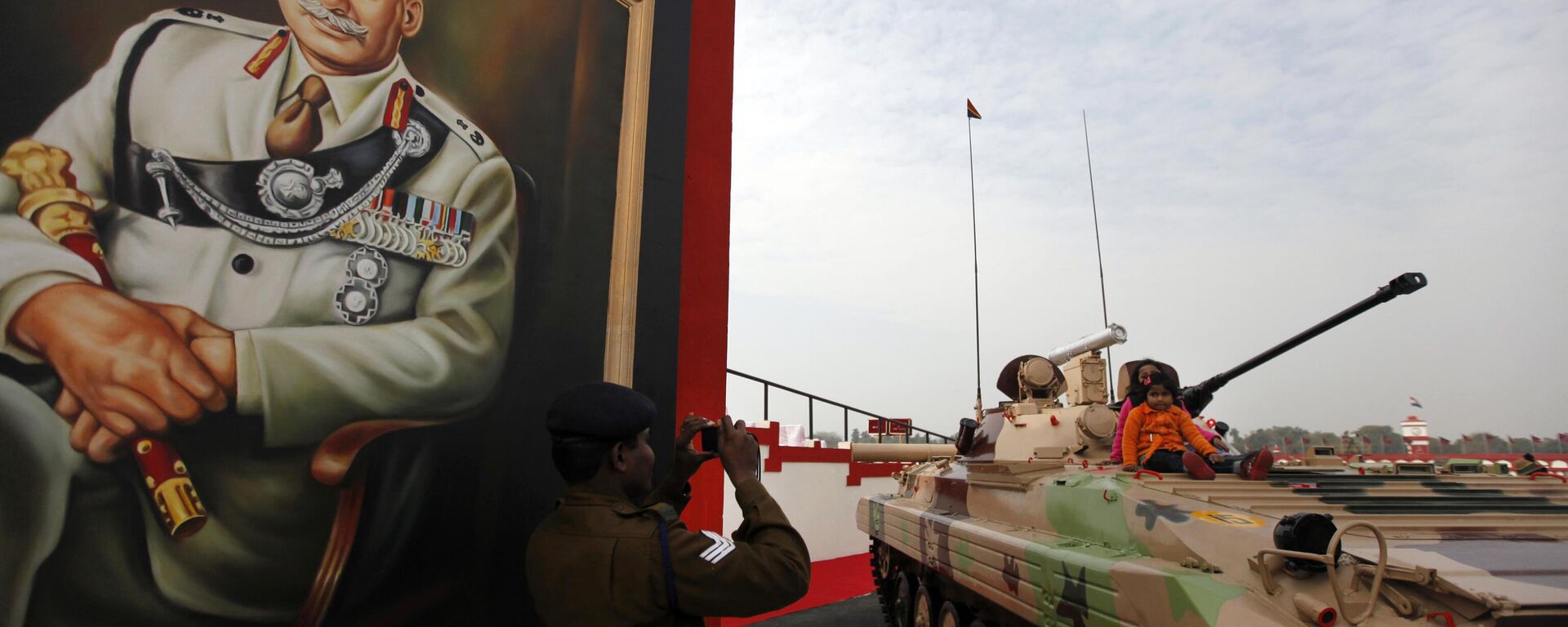 An Indian army soldier photographs his children atop a BMP armored personnel carrier on the occasion of the Indian Army Day in New Delhi, India, Sunday, Jan. 15, 2012. On the left is a portrait of Field Marshal Sam Manekshaw. - Sputnik भारत, 1920, 27.06.2024