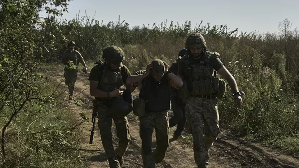Ukrainian servicemen help to evacuate a wounded soldier on Aug. 30, 2023.  - Sputnik India