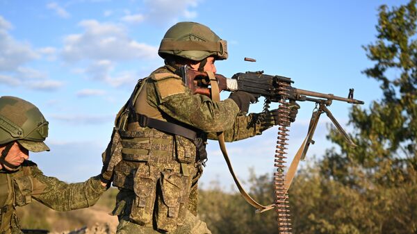 A Russian serviceman shoots a machine gun - Sputnik India