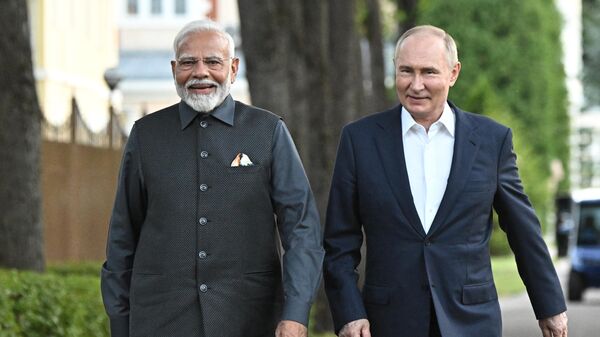 In this pool photograph distributed by the Russian state agency Sputnik, Russia's President Vladimir Putin and Indian Prime Minister Narendra Modi take a walk during an informal meeting at the Novo-Ogaryovo state residence, outside Moscow, on July 8, 2024. - Sputnik India