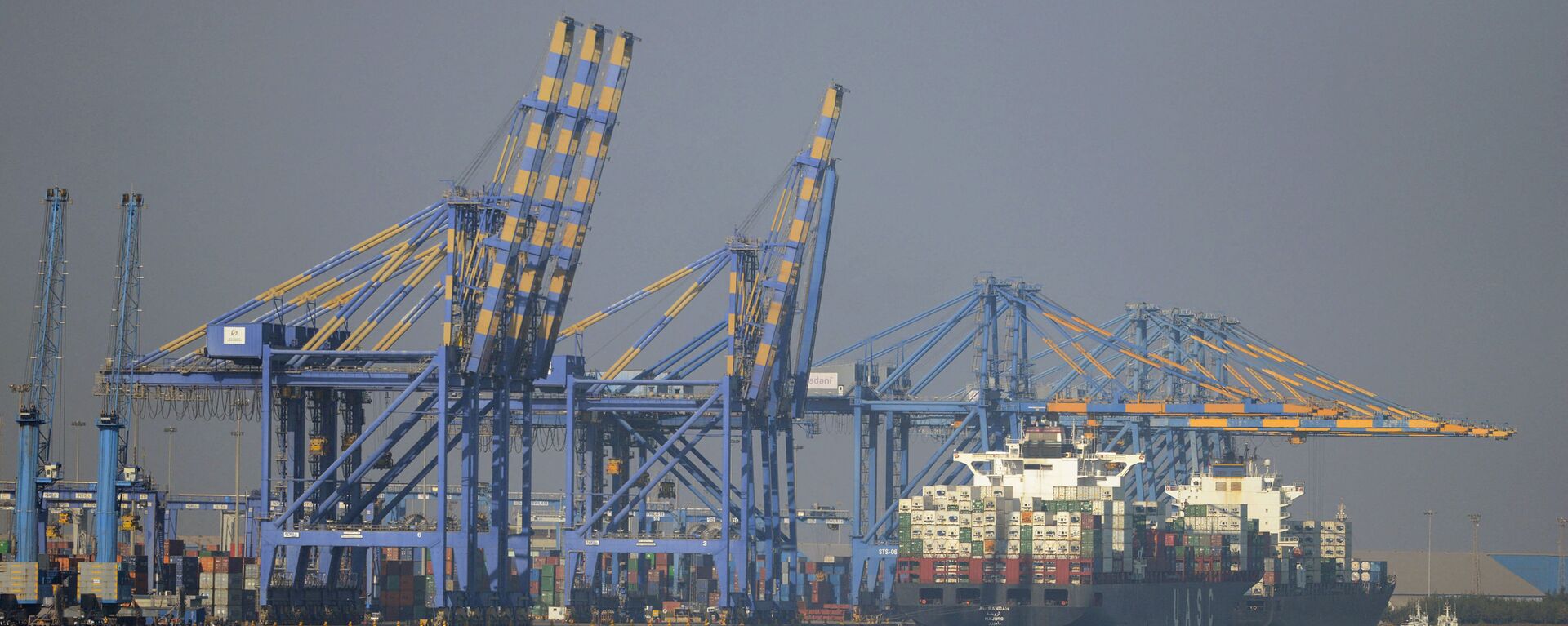 This photo taken on December 21, 2016 shows a container ship (R) docked at India's Adani Port Special Economic Zone (APSEZ) in Mundra - Sputnik India, 1920, 16.07.2024