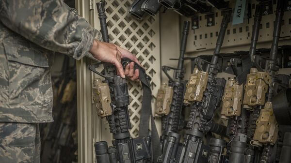 In this April 2, 2015, photo made available by the U.S. Air Force, a senior airman from the 49th Security Forces Squadron in charge of the armory,  returns an M4 carbine to a rack at Holloman Air Force Base, N.M. The Pentagon used to share annual updates about missing weapons with Congress, but that requirement ended and, with it, public accountability has slipped. The Army and Air Force couldn’t readily tell AP how many weapons they were missing from 2010 through 2019. (Airman 1st Class Aaron Montoya/U.S. Air Force via AP) - Sputnik India