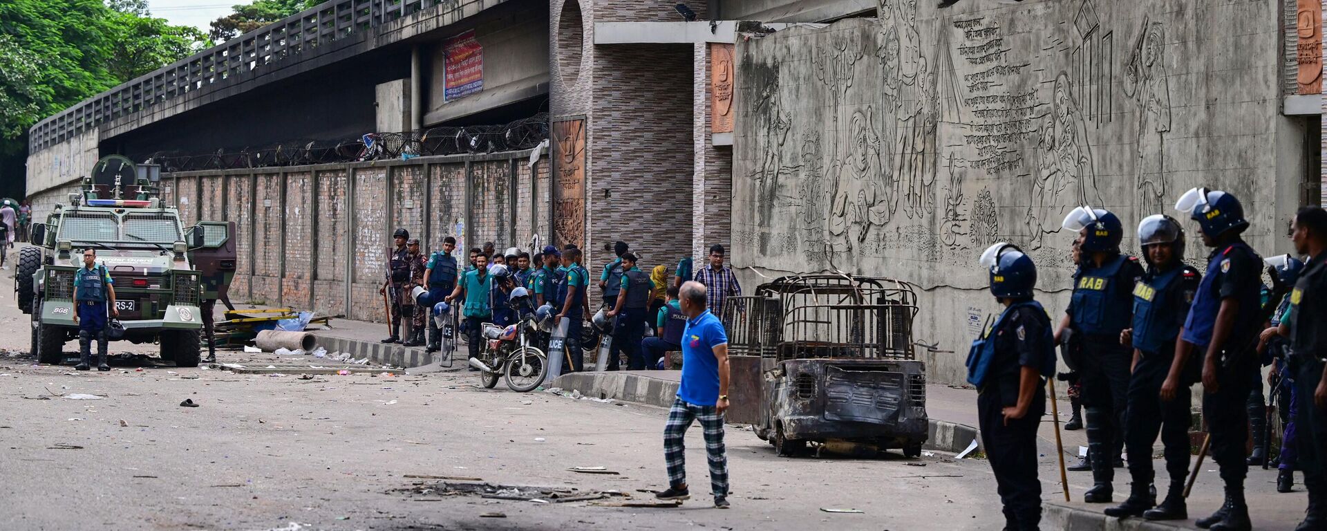 Police stand guard at the headquarters of state broadcaster Bangladesh Television, after students set it on fire amid the ongoing anti-quota protest in Dhaka on July 19, 2024. - Sputnik भारत, 1920, 21.07.2024