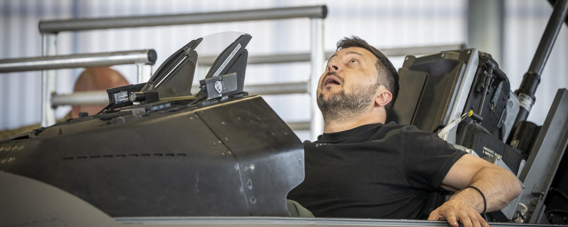 Ukrainian President Volodymyr Zelensky sits in a F-16 fighter jet in the hangar of the Skrydstrup Airbase in Vojens, northern Denmark, on August 20, 2023. Washington has told Denmark and the Netherlands that they will be permitted to hand over their F-16 fighter jets to Ukraine when the country's pilots are trained to operate them, the US State Department said on August 18, 2023. Both Denmark and the Netherlands are leading the program to train Ukraine's pilots on the F-16. - Sputnik भारत, 1920, 24.07.2024