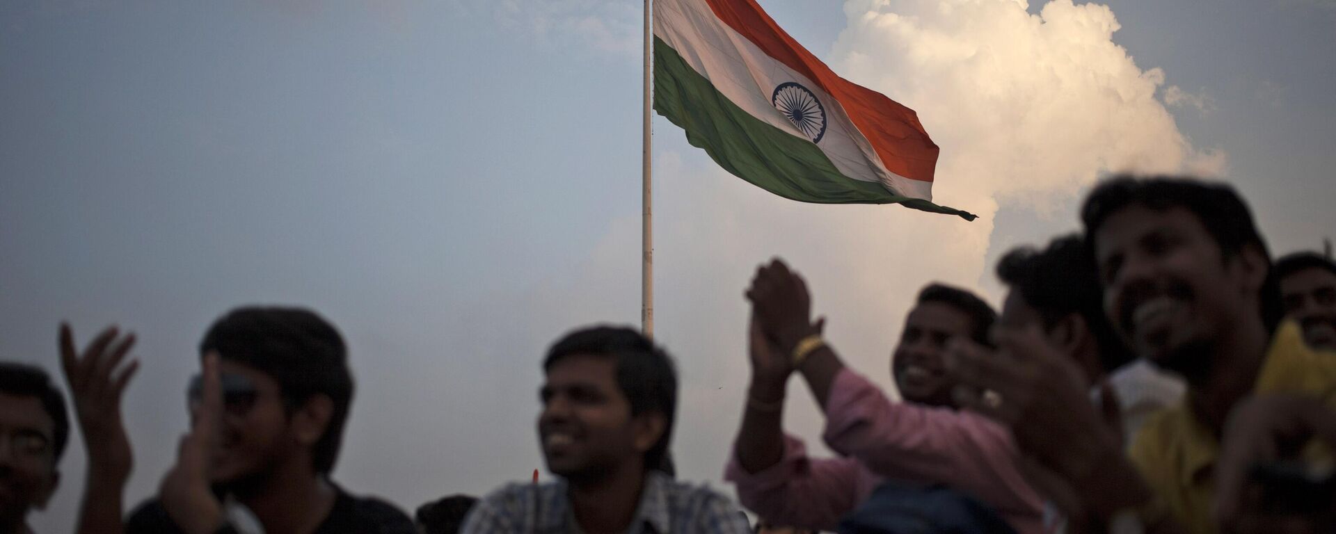 Indians applaud as they watch a musical tribute to war heroes on the 15th anniversary of India's victory in the Kargil War, as a national flag flies in New Delhi, India, Saturday, July 26, 2014.  - Sputnik भारत, 1920, 25.07.2024