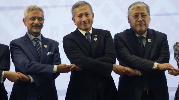 Indian Foreign Minister Subramanyam Jaishankar, Singapore's Foreign Minister Vivian Balakrishnan and Philippine Foreign Secretary Enrique Manalo hold hands for a group photo at the ASEAN Post Ministerial Conference with India - Sputnik भारत