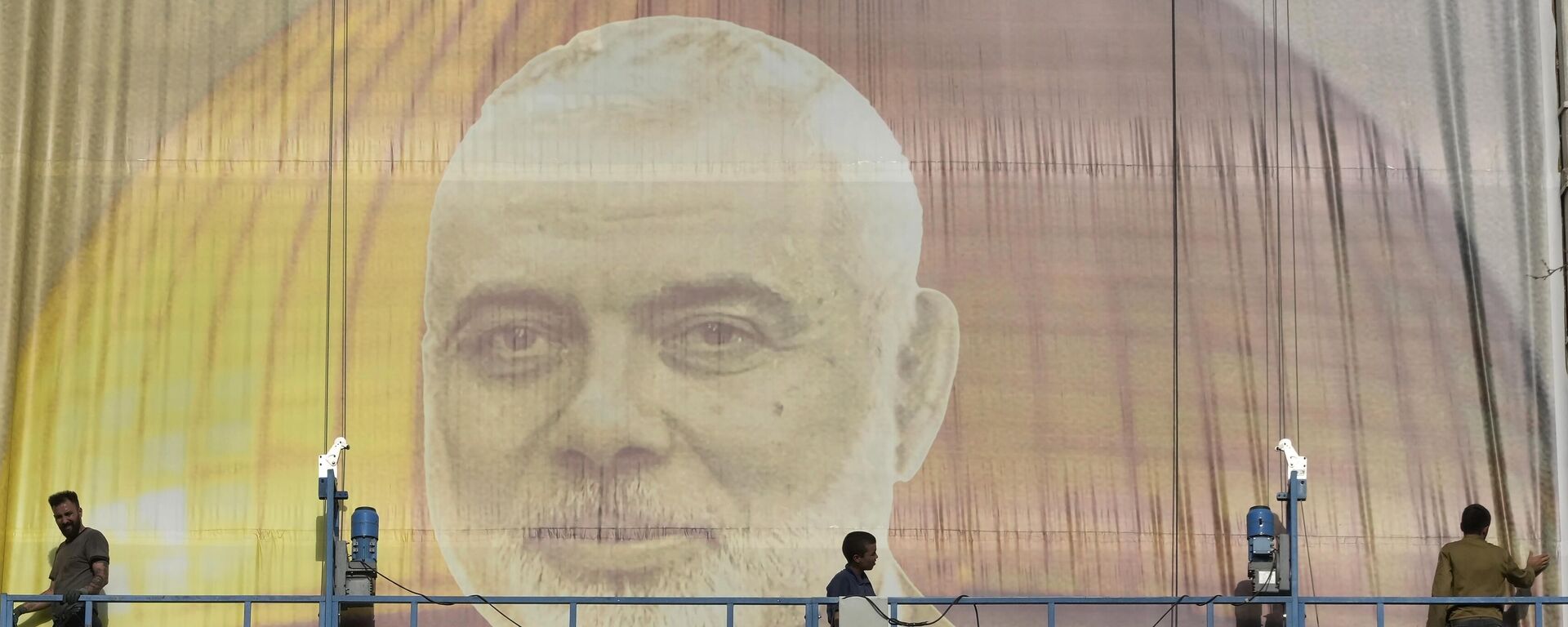 Iranian workers install a huge banner on a wall showing a portrait of Hamas leader Ismail Haniyeh and the Dome of Rock Mosque at the Al-Aqsa Mosque compound of Jerusalem at Felestin (Palestine) Sq. in Tehran, Iran, Wednesday, July 31, 2024. Haniyeh was assassinated in Tehran, Iran's paramilitary Revolutionary Guard said early Wednesday.  - Sputnik India, 1920, 03.08.2024