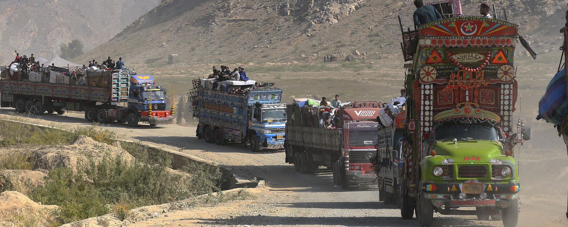 A convey of trucks carrying Afghan families drive toward a border crossing point in Torkham, Pakistan, Tuesday, Oct. 31, 2023.  - Sputnik India, 1920, 30.08.2024