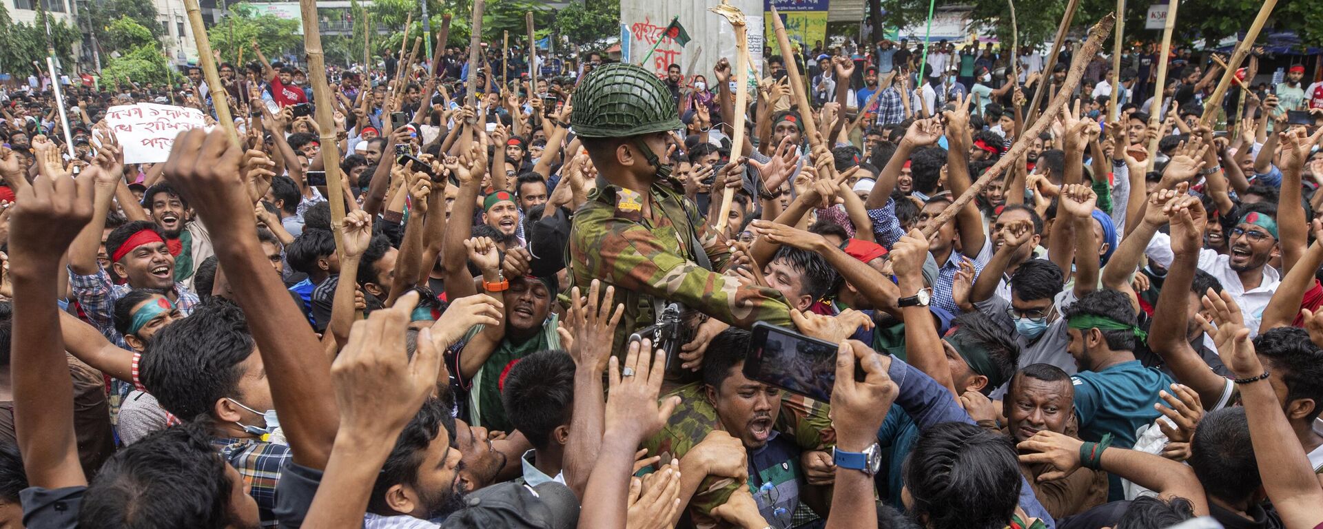 Protesters carry a member of the army on their shoulders as they celebrate Prime Minister Sheikh Hasina's resignation, in Dhaka, Bangladesh, Monday, Aug. 5, 2024. (AP Photo/Rajib Dhar) - Sputnik India, 1920, 07.08.2024