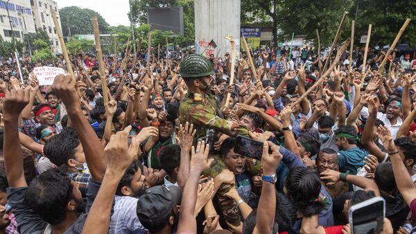 Protesters carry a member of the army on their shoulders as they celebrate Prime Minister Sheikh Hasina's resignation, in Dhaka, Bangladesh, Monday, Aug. 5, 2024. (AP Photo/Rajib Dhar) - Sputnik India