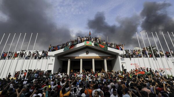 People hanging Bangladesh’s national flag during the storming of Prime Minister Sheikh Hasina’s palace in Dhaka - Sputnik India