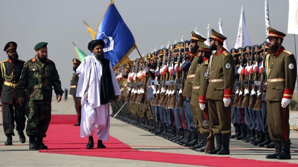 Mullah Abdul Ghani Baradar, the Taliban-appointed deputy prime minister for economic affairs, center, inspects the honor guards during a military parade to mark the third anniversary of the withdrawal of U.S.-led troops from Afghanistan, in Bagram Air Base in the Parwan Province of Afghanistan, Wednesday, Aug. 14, 2024. - Sputnik भारत