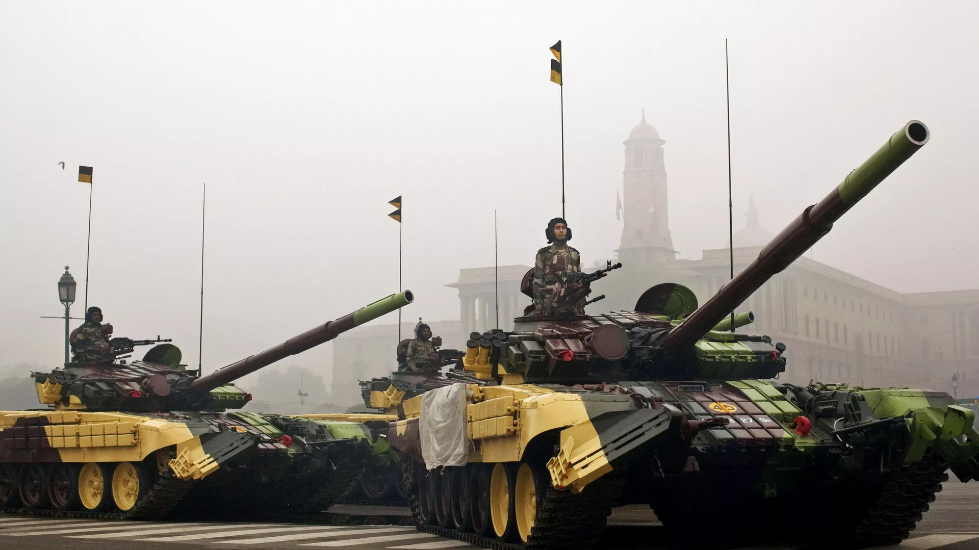 Indian soldiers ride in T-72 tanks in the fog in preparation for Republic Day celebrations near the Presidential Palace in New Delhi, India, Tuesday, Jan. 17, 2012.