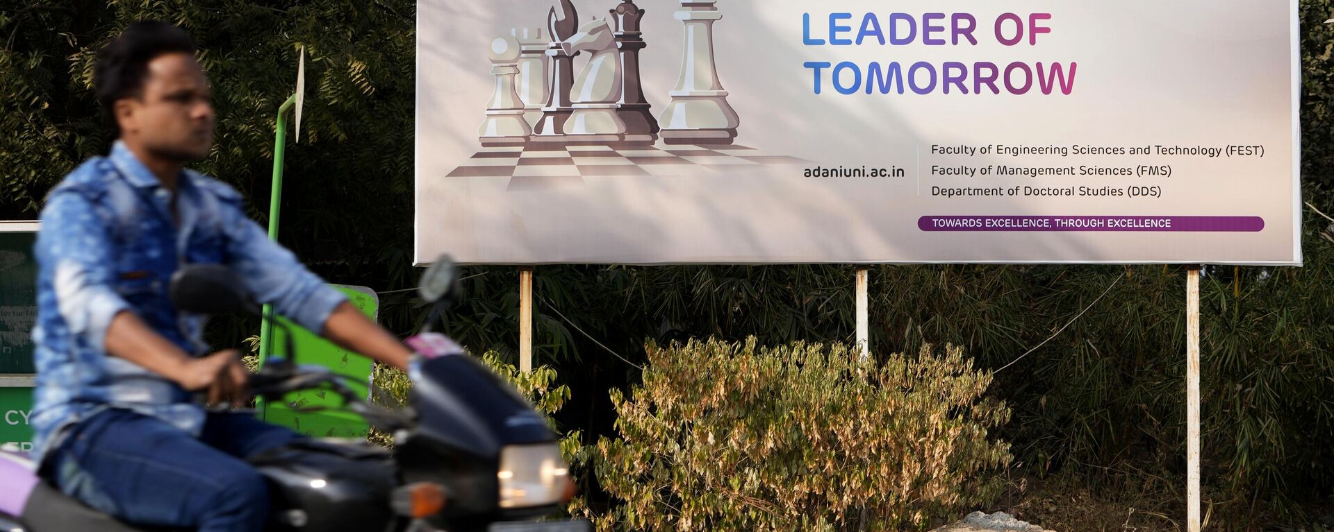 A motorist rides past a hoarding of Adani University near the corporate headquarters of Adani Group in Ahmedabad, India, Friday, Jan. 27, 2023. - Sputnik India, 1920, 22.09.2024