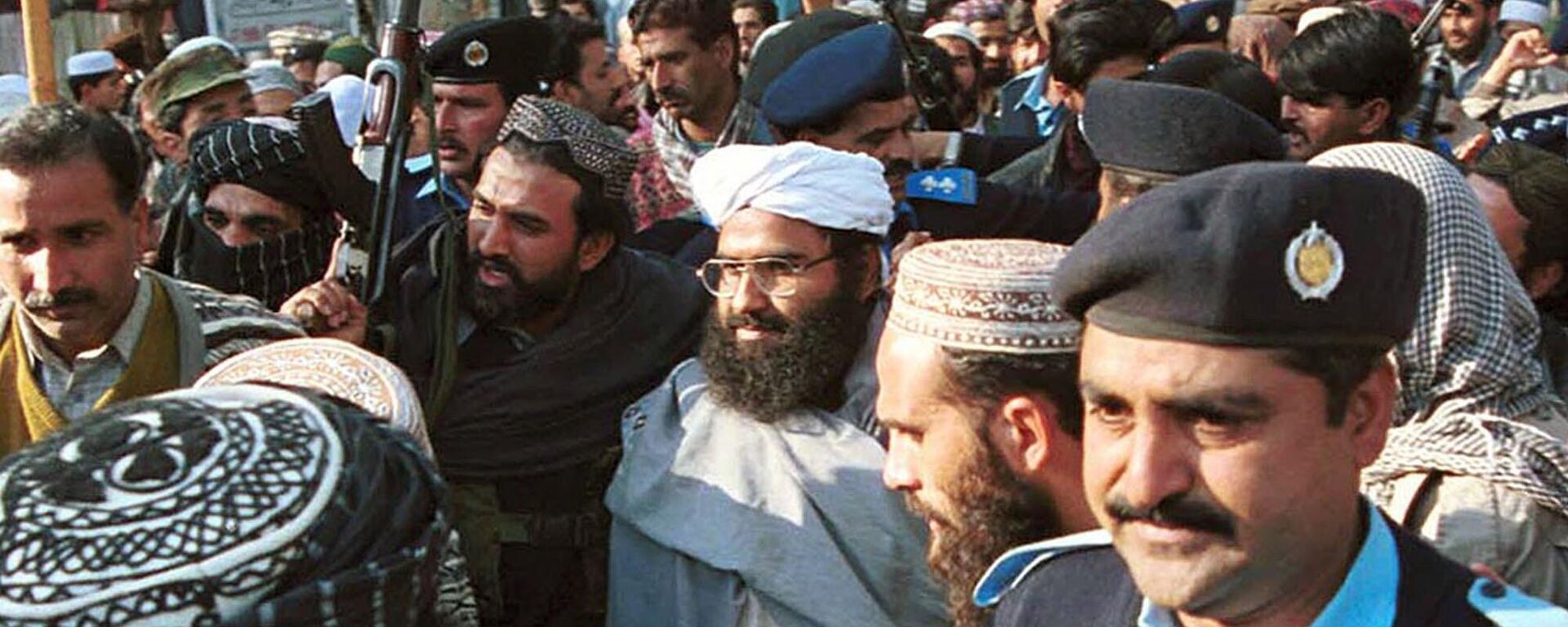 FILE - In this Jan. 27, 2000 file photo, leader of a militant group Masood Azhar, center wearing glasses and white turban, arrives in Islamabad, Pakistan. India placed the blame for the Thursday, Feb. 14, 2019 bombing squarely on neighboring Pakistan, which India accuses of supporting rebels in Kashmir. The Greater Kashmir newspaper reported that a militant group Jaish-e-Mohammed, headquartered in Pakistan, claimed responsibility. India's foreign ministry on Friday, Feb. 15, 2019 briefed New Delhi-based diplomats of key countries, including China, which has in the past blocked India's proposal to list Jaish-e-Mohammed chief Masood Azhar as a designated terrorist by the United Nations. (AP Photo/Mian Khursheed, file) - Sputnik India, 1920, 09.10.2024