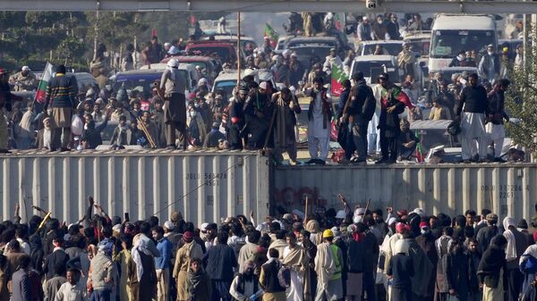 Supporters of imprisoned former premier Imran Khan's Pakistan Tehreek-e-Insaf party, remove shipping container to clear way for their rally demanding Khan's release, in Islamabad, Pakistan, Tuesday, Nov. 26, 2024. (AP Photo/Anjum Naveed) - Sputnik India