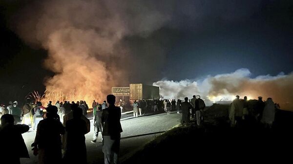 Supporters of imprisoned former premier Imran Khan's Pakistan Tehreek-e-Insaf party, burn bushes to reduce the impact of tear gas shells fired by police officers to disperse them during a rally demanding Khan's release, at a motorway in Ghazi in Attock district, Pakistan, Sunday, Nov. 24, 2024. - Sputnik भारत