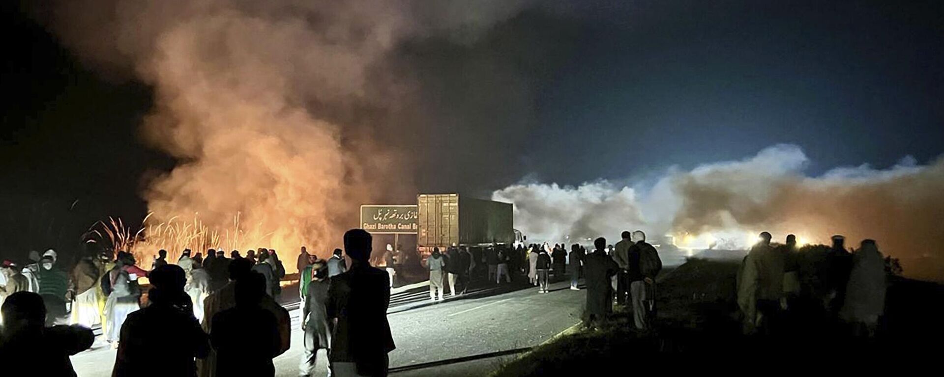 Supporters of imprisoned former premier Imran Khan's Pakistan Tehreek-e-Insaf party, burn bushes to reduce the impact of tear gas shells fired by police officers to disperse them during a rally demanding Khan's release, at a motorway in Ghazi in Attock district, Pakistan, Sunday, Nov. 24, 2024. - Sputnik भारत, 1920, 28.11.2024