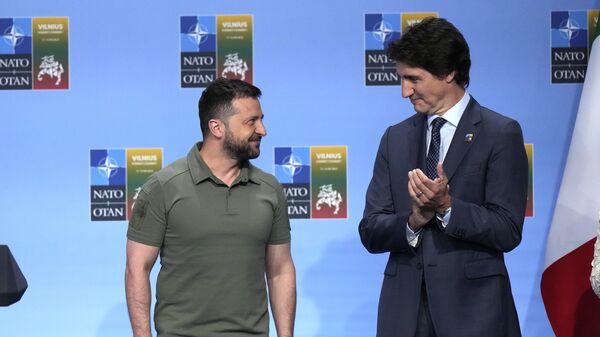 Canada's Prime Minister Justin Trudeau, right, applauds during an address by United States President Joe Biden, with other G7 countries, and Ukraine's President Volodymyr Zelenskyy during a NATO summit in Vilnius, Lithuania, Wednesday, July 12, 2023. (AP Photo/Pavel Golovkin) - Sputnik India