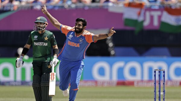 India's Jasprit Bumrah, right, celebrates the dismissal of Pakistan's captain Babar Azam during the ICC Men's T20 World Cup cricket match between India and Pakistan at the Nassau County International Cricket Stadium in Westbury, New York, Sunday, June 9, 2024. (AP Photo/Adam Hunger) - Sputnik India