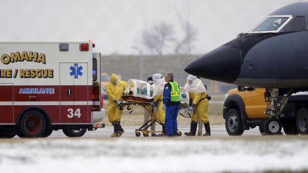 FILE - In this file photo from Nov. 15, 2014, medical workers in protective suits transport Dr. Martin Salia, a surgeon working in Sierra Leone who had been diagnosed with Ebola, from a jet that brought him from Sierra Leone to a waiting ambulance that will take him to the Nebraska Medical Center in Omaha, Neb.  The World Health Organization says Thursday, March 12, 2015, its tally of Ebola deaths has passed the grim milestone of 10,000, mostly in West Africa. (AP Photo/Nati Harnik, File) - Sputnik India