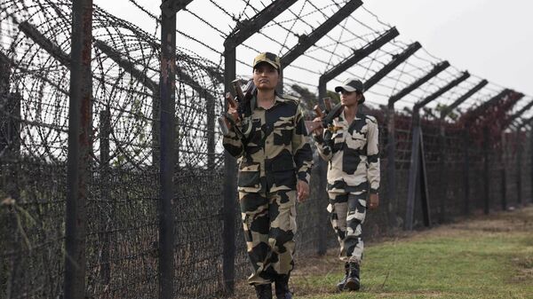 Indian Border Security Force personnel patrol past a fence on the India- Bangladesh border at Thakuranbari village, in the northeastern Indian state of Assam, Friday, Sept. 2, 2016. - Sputnik India