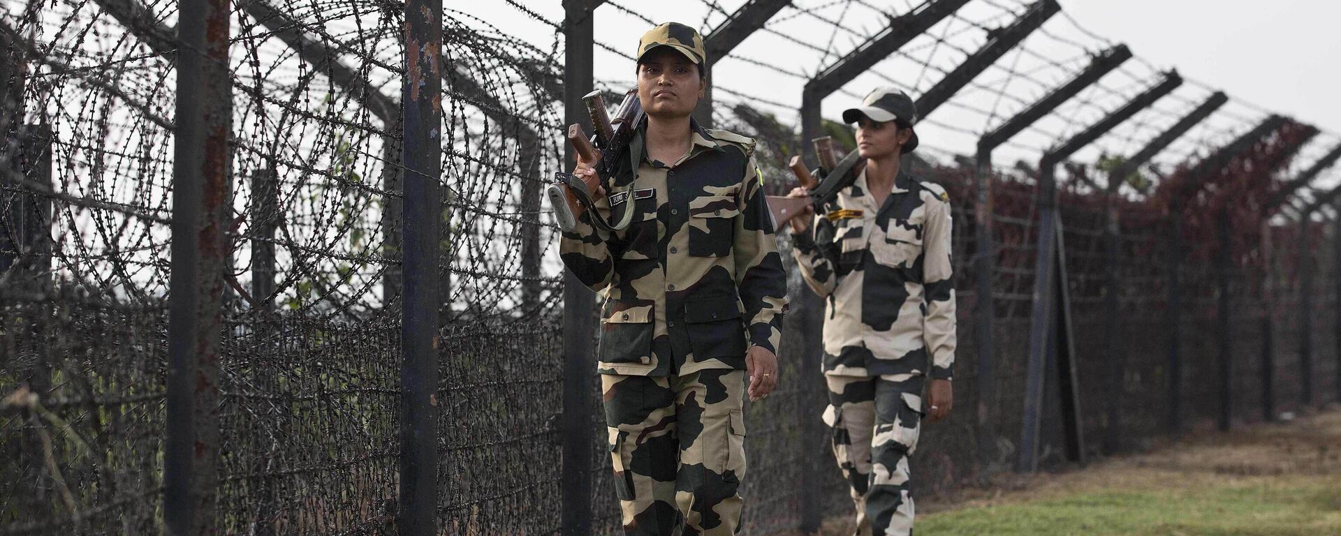 Indian Border Security Force personnel patrol past a fence on the India- Bangladesh border at Thakuranbari village, in the northeastern Indian state of Assam, Friday, Sept. 2, 2016. - Sputnik भारत, 1920, 15.01.2025