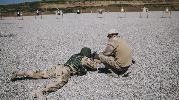 In this March 9, 2016 file image, a Dutch army trainer, right, helps a Kurdish Peshmerga soldier during a military training session at a shooting range, at Bnaslawa Military Base in Irbil, northern Iraq.  - Sputnik भारत