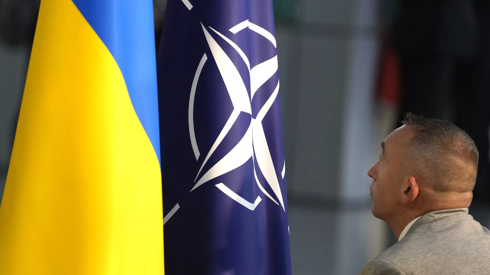 A member of protocol sets up the NATO and Ukrainian flags in Brussels, Wednesday, Oct. 11, 2023.