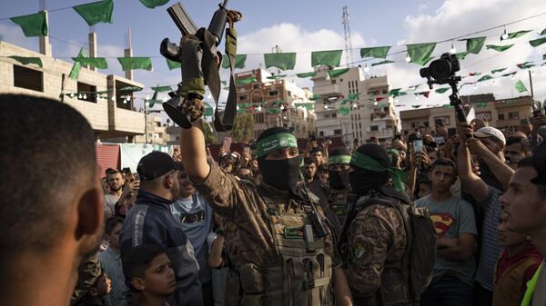 A member of Hamas' military wing raises a rifle seized from Israeli security forces during an arms show for the group at Nusseirat refugee camp, central Gaza Strip, Friday, June 30, 2023 - Sputnik भारत