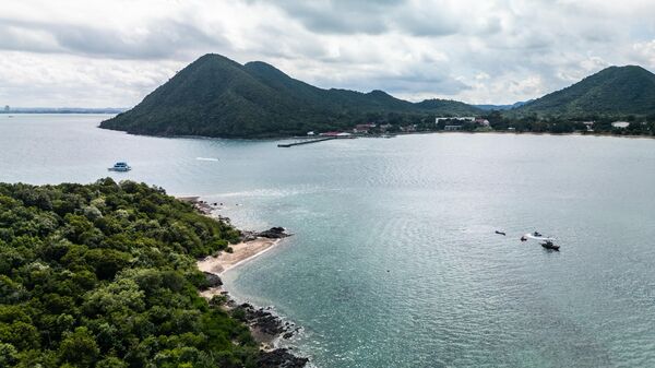 PATTAYA, THAILAND - AUGUST 23: An aerial view of Khram Yai island on August 23, 2024 in Pattaya, Thailand. Khram Yai Island, off the coast of Pattaya, is a protected area under the Royal Thai Navy, known for its rich marine biodiversity, including coral reefs and as a key nesting site for green and hawksbill turtles. While often associated with tourism and nightlife, Pattaya is also home to diverse ecosystems that contribute to the region's rich biodiversity, particularly in areas like Naklua. The Naklua area, including Koh Larn and Koh Phae, contains ecosystems crucial to this biodiversity, such as mangrove forests and coral reefs. To counter threats from urban development and tourism, local and government initiatives like coral restoration, mangrove reforestation, and marine conservation are underway. These efforts aim to preserve Pattaya's ecological balance and ensure sustainable growth. (Photo by Lauren DeCicca/Getty Images) - Sputnik India