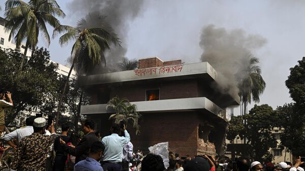 People stand around a burning building, which is part of the residence of Sheikh Mujibur Rahman, Bangladesh's former leader and the father of the country's ousted Prime Minister Sheikh Hasina, in Dhaka, Bangladesh, Thursday, Feb. 6, 2025. (AP Photo/Mahmud Hossain Opu) - Sputnik India