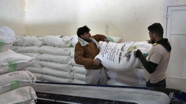 Workers load bags of flour into a truck at the Big Mills factory in the southern town of Sebline, south of Beirut, Lebanon, March 15, 2022. - Sputnik भारत