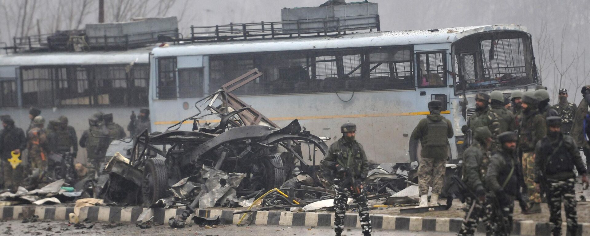 SRINAGAR, INDIA - FEBRUARY 14: Security forces near the damaged vehicles at Lethpora on the Jammu-Srinagar highway, on February 14, 2019 in Srinagar, India. At least 30 CRPF jawans were killed and many others injured in an improvised explosive device (IED) blast at Lethpora. Police sources say that the attack was likely carried out by a suicide bomber, who rammed an explosive-laden car into the CRPF bus. The bus was part of an army convoy coming from Jammu to Srinagar. (Photo by Waseem Andrabi/Hindustan Times via Getty Images) - Sputnik India, 1920, 14.02.2025