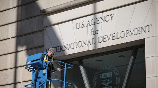 WASHINGTON, DC - FEBRUARY 07: A worker removes the U.S. Agency for International Development sign on their headquarters on February 07, 2025 in Washington, DC. President Donald Trump and Elon Musk's Department of Government Efficiency (DOGE) abruptly shutdown the U.S. aid agency earlier this week leaving thousands unemployed and putting U.S. foreign diplomacy and aid programs in limbo.  (Photo by Kayla Bartkowski/Getty Images) - Sputnik India