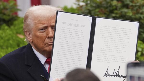 President Donald Trump holds a signed executive order during an event to announce new tariffs in the Rose Garden of the White House, Wednesday, April 2, 2025, in Washington - Sputnik भारत