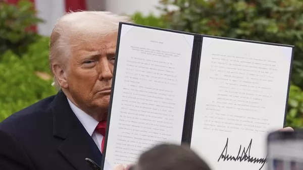 President Donald Trump holds a signed executive order during an event to announce new tariffs in the Rose Garden of the White House, Wednesday, April 2, 2025, in Washington - Sputnik भारत