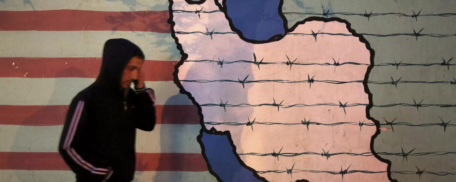A man walks past an anti-U.S. mural, painted on the wall of the former U.S. Embassy, in Tehran, Iran, Saturday, Nov. 2, 2013. - Sputnik भारत, 1920, 08.04.2025