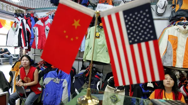 Chinese vendors at a clothing stall wait near Chinese and US flags for customers in Beijing, China, Tuesday, Sept 6, 2005.  - Sputnik India