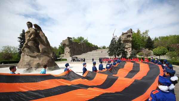 A massive georgian ribbon being carried at the Mamayev Kurgan in the city of Volgograd (former Stalingrad) - Sputnik भारत