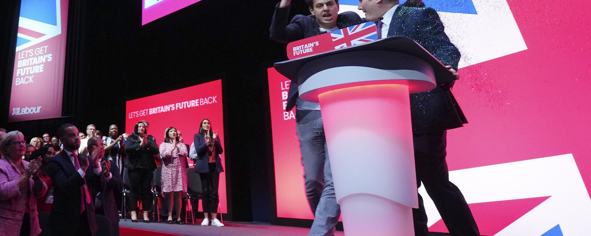 An unidentified man throw confetti as Britain's opposition Labour Party leader Keir Starmer speaks at the Labour Party conference in Liverpool, England, Tuesday, Oct. 10, 2023. - Sputnik भारत, 1920, 13.05.2025