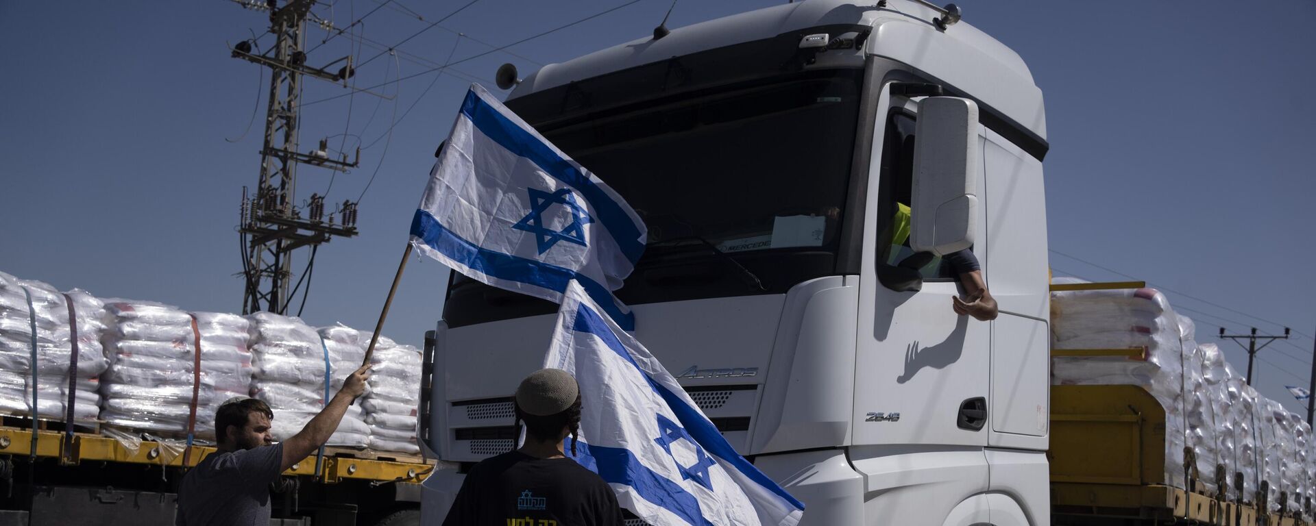 Activists stand in front of trucks carrying humanitarian aid as they try to stop them from entering the Gaza Strip in an area near the Kerem Shalom border crossing, southern Israel, Thursday, May 9, 2024.  - Sputnik भारत, 1920, 19.05.2025