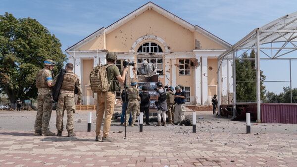 A group of journalists and Ukrainian soldiers are seen in front of a completely demolished monument of Vladimir Lenin in the centre square while a burnt Russian flag is on the ground in Sudzha.  - Sputnik भारत