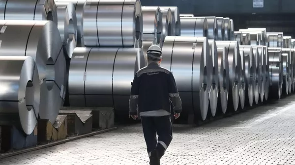 A steel worker walks beside steel coils during a visit of EU Commissioner for Prosperity and Industrial Strategy Stephane Sejourne at the Thyssenkrupp steelworks in Duisburg, Germany, on March 20, 2025.  - Sputnik India