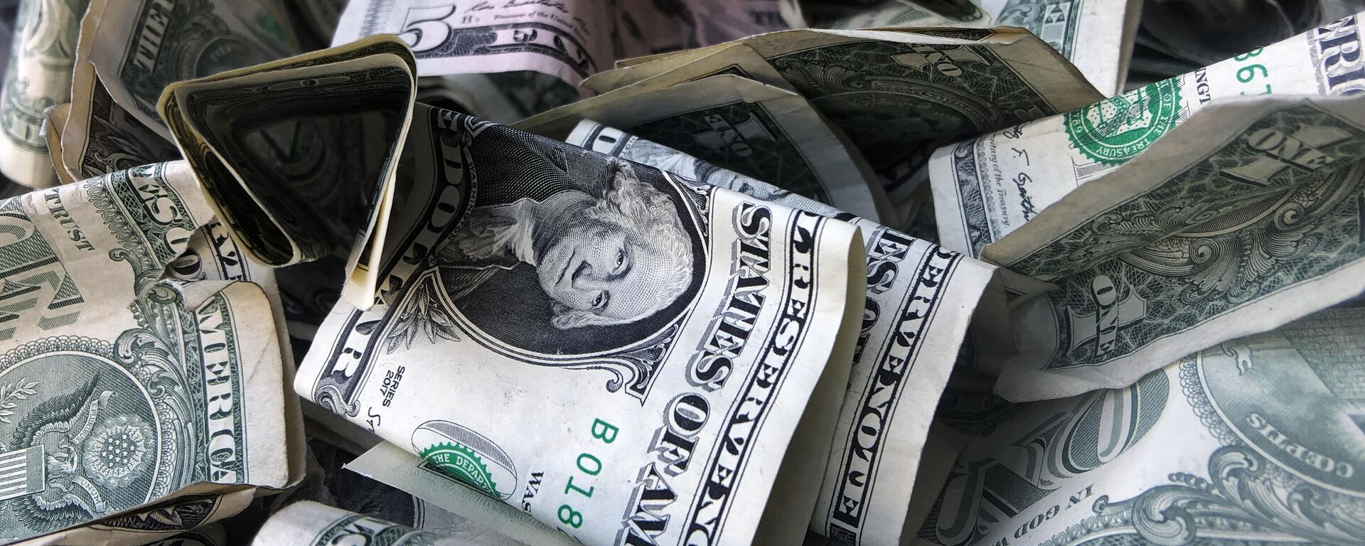 This Wednesday, April 3, 2019, file photo shows a box filled with dollar bills, in New York. - Sputnik India, 1920, 07.06.2025