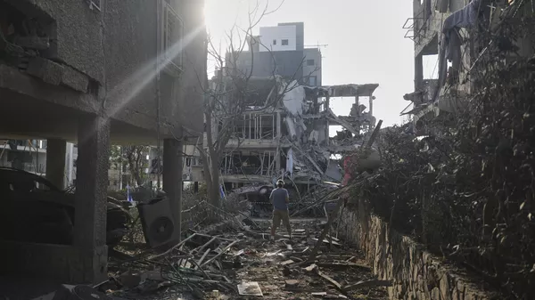 People look at a destroyed residential building that was hit by a missile fired from Iran, in Ramat Gan, near Tel Aviv, Israel on Saturday, June 14, 2025.  - Sputnik भारत